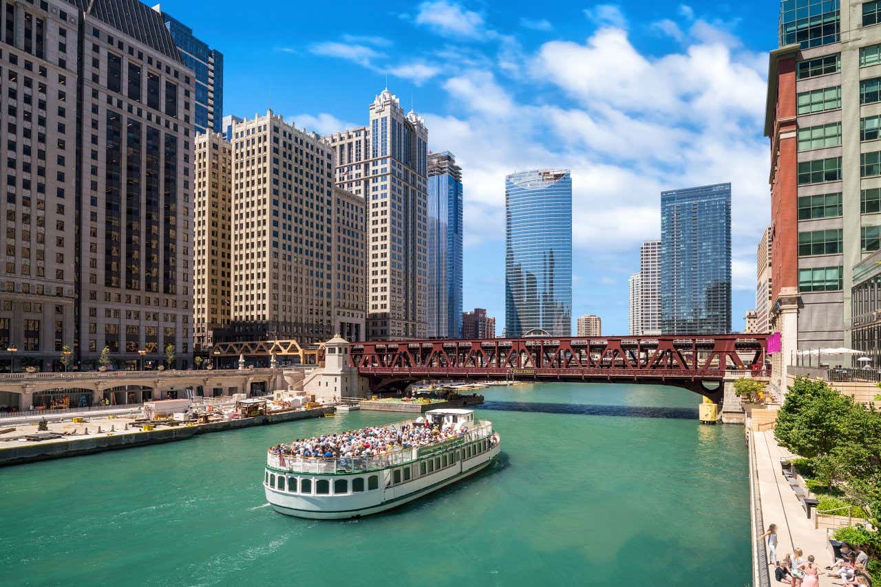 Bateau sur la Chicago River avec des gratte-ciels autour par temps ensoleillé