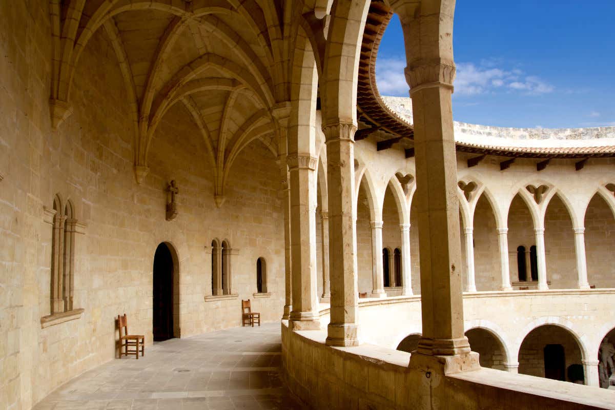 Pasadizo circular con arcos de piedra que recorren el claustro de un castillo