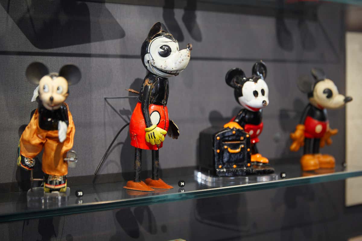 Small toys depicting Mickey Mouse on the shelf of a Walt Disney museum in San Francisco.