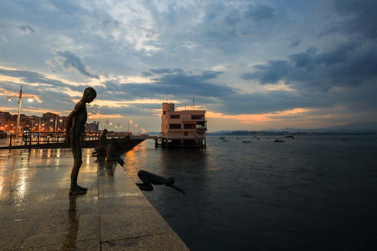 Sculture di ragazzini che si tuffano in mare da un lungomare al tramonto