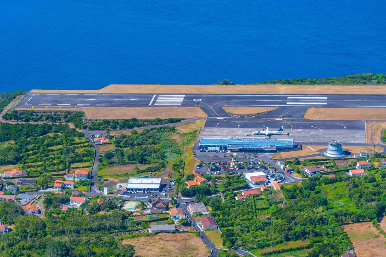 Una pista di atterraggio affacciata sul mare e circondata da poche case e alberi