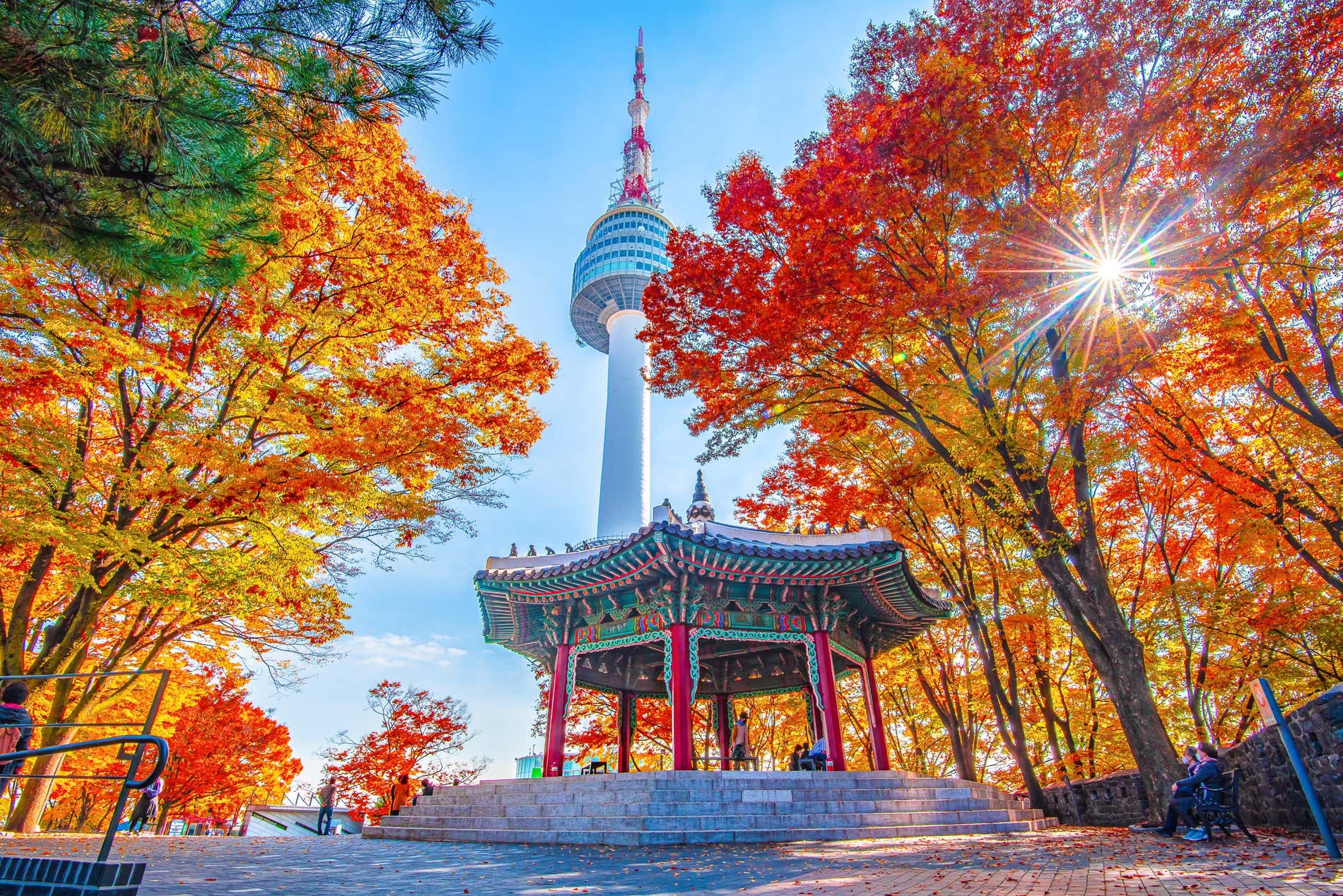 La N Tower in Corea del Sud è visibile sullo sfondo, in primo piano un antico tempio circondato da alberi autunnali