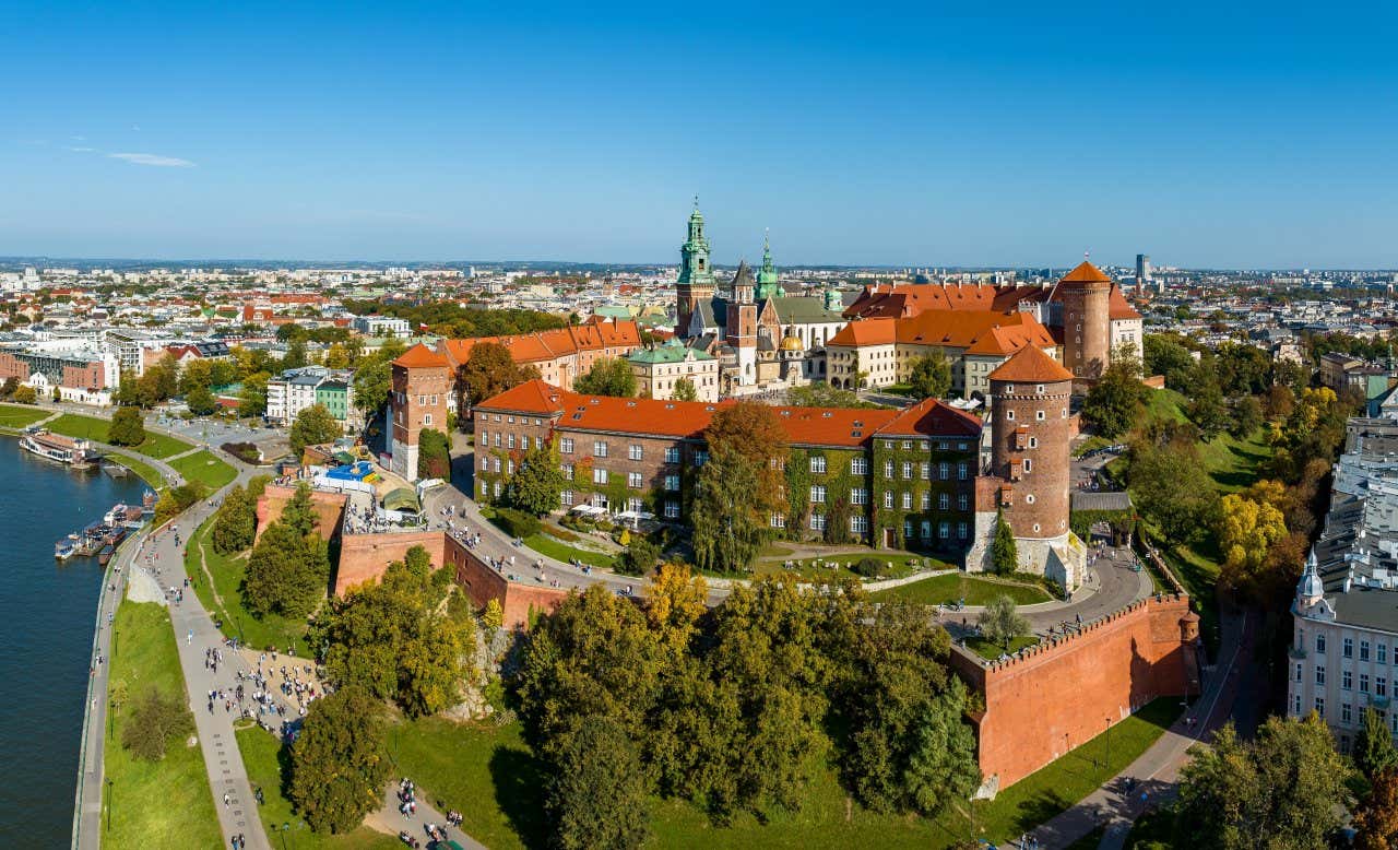 An aerial view of Wawel Royal Hill with a clear blue sky in the background and the river at the bottom of the page.