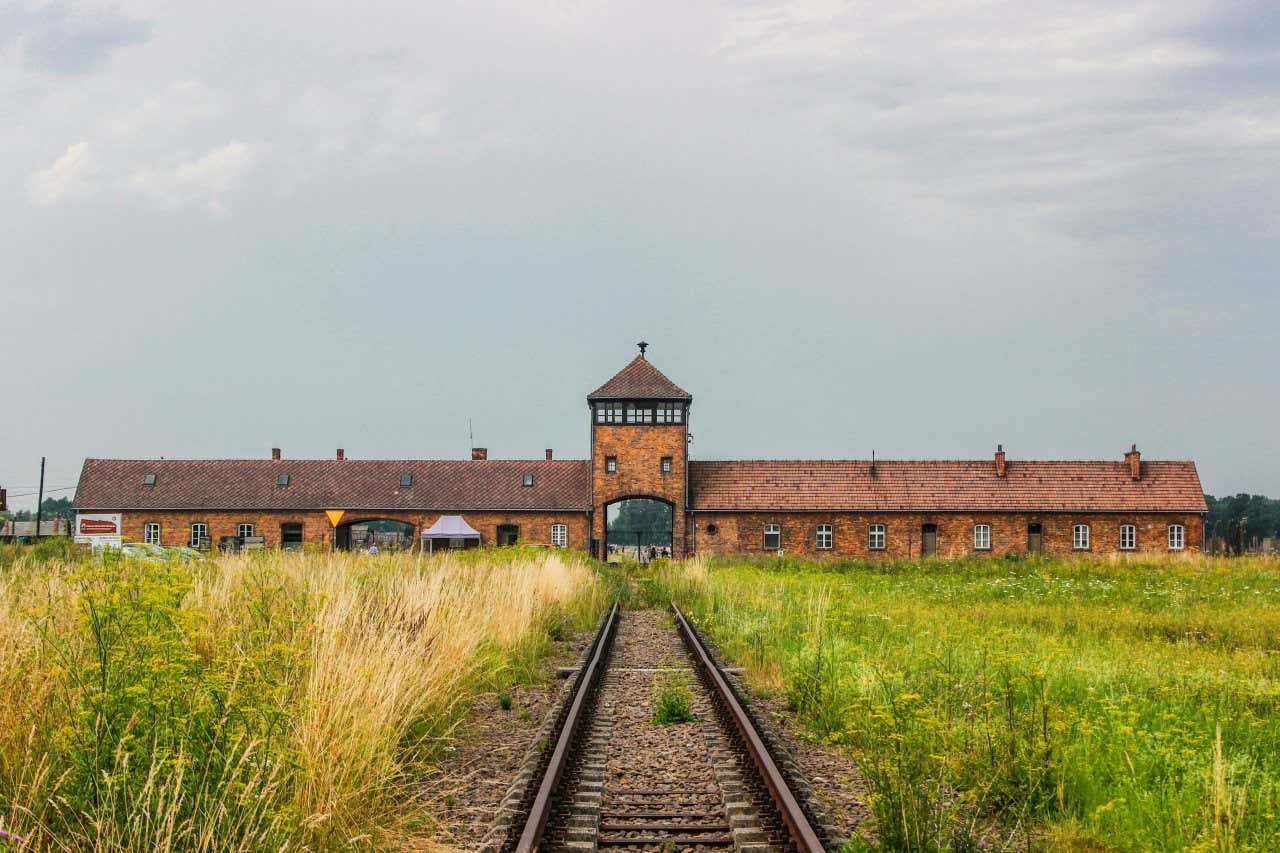 The front of the Auschwitz Concentration Camp with a grey sky in the background.