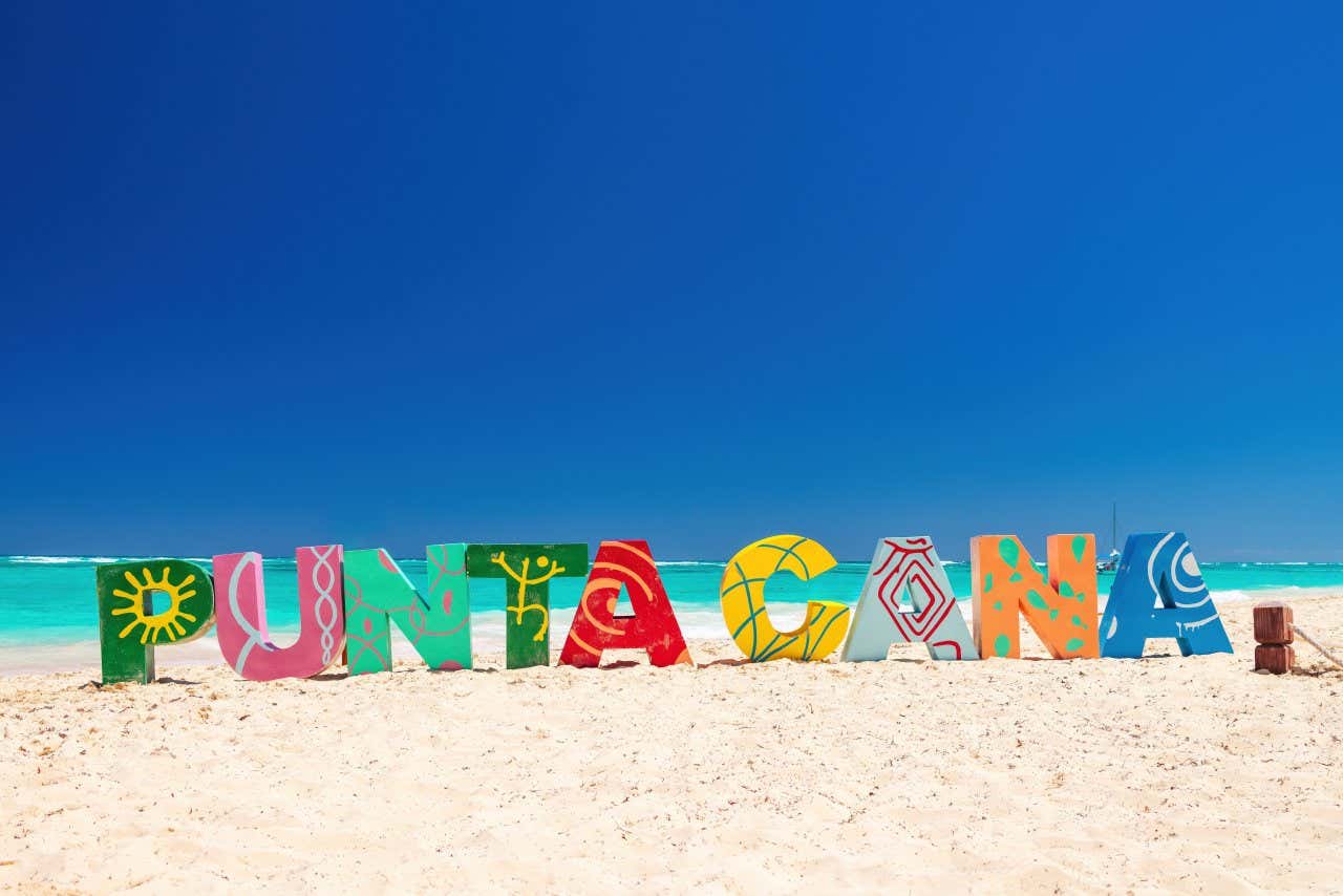 Large colorful letters on the beach that say 'Punta Cana'