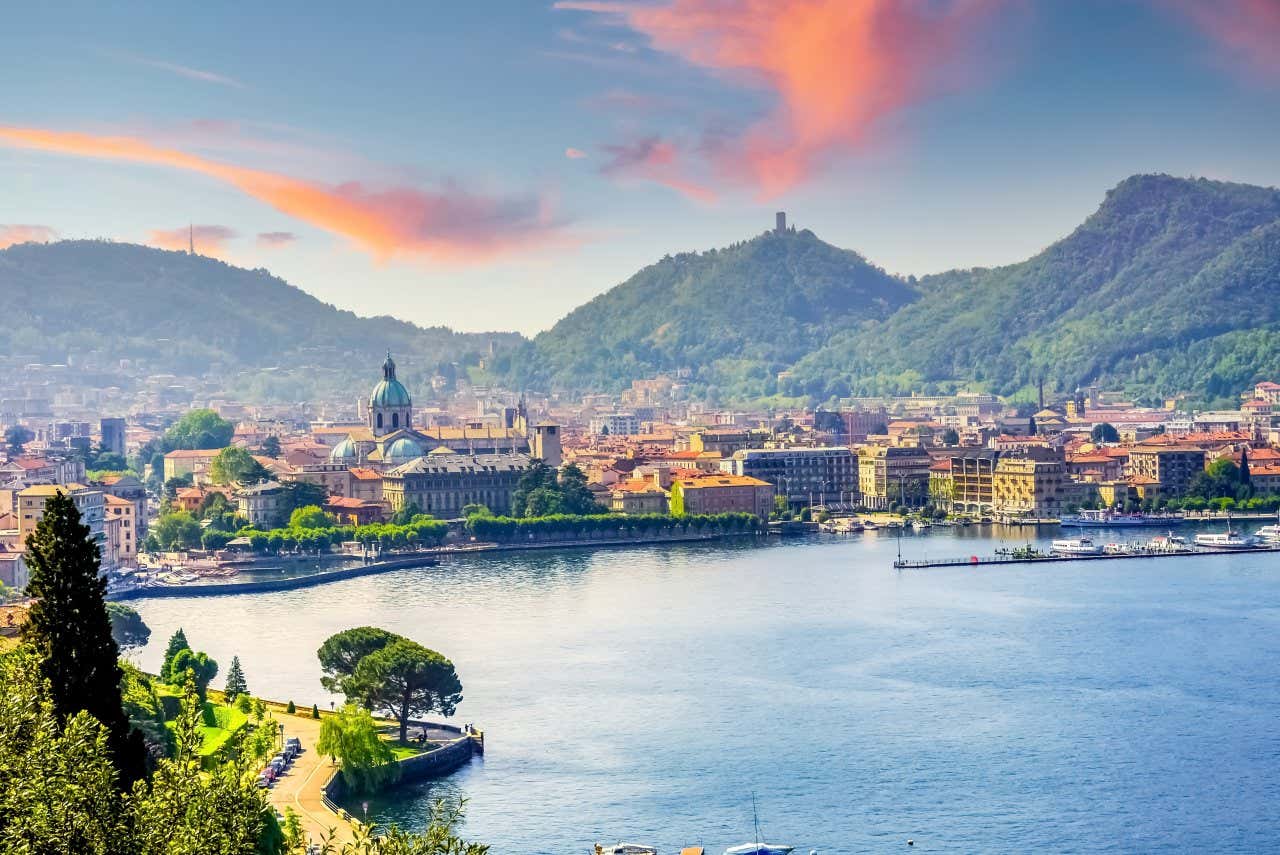 Vista di Como immersa tra verdi colline e affacciata sul lago di Como, uno dei laghi più belli d'Italia, in un pomeriggio soleggiato