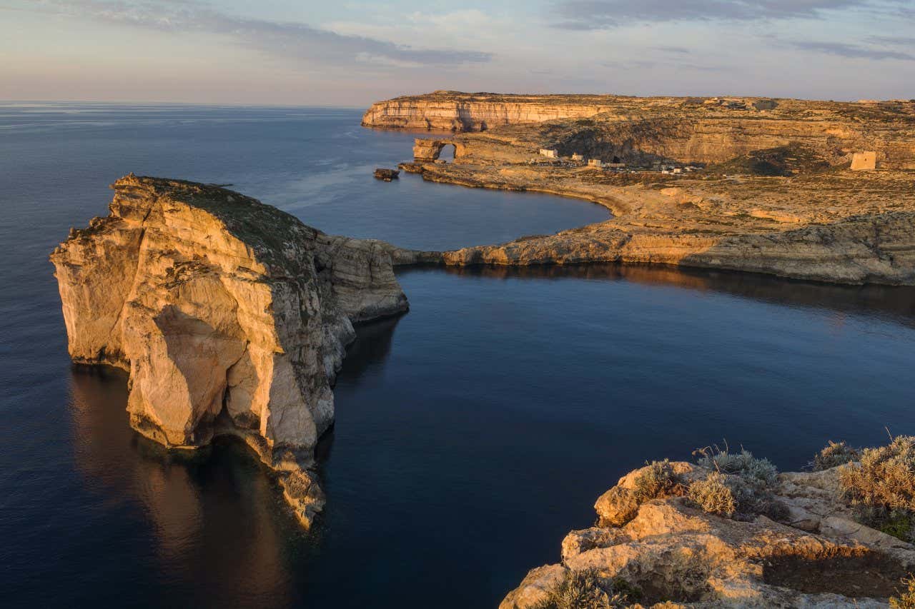 D'imposantes formations rocheuses en bord de mer au coucher du soleil