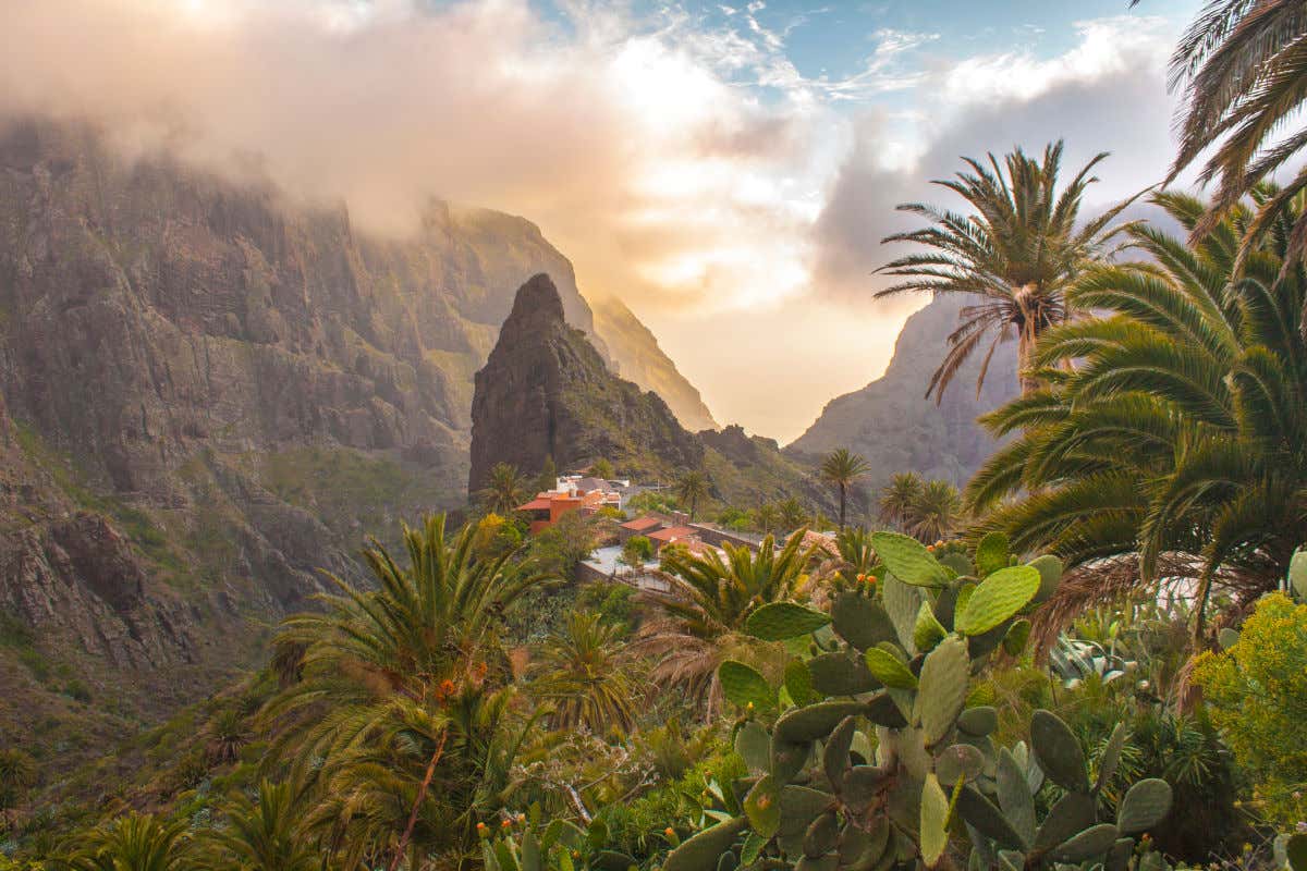 A huge rock among high mountains and with a small hamlet in Tenerife.