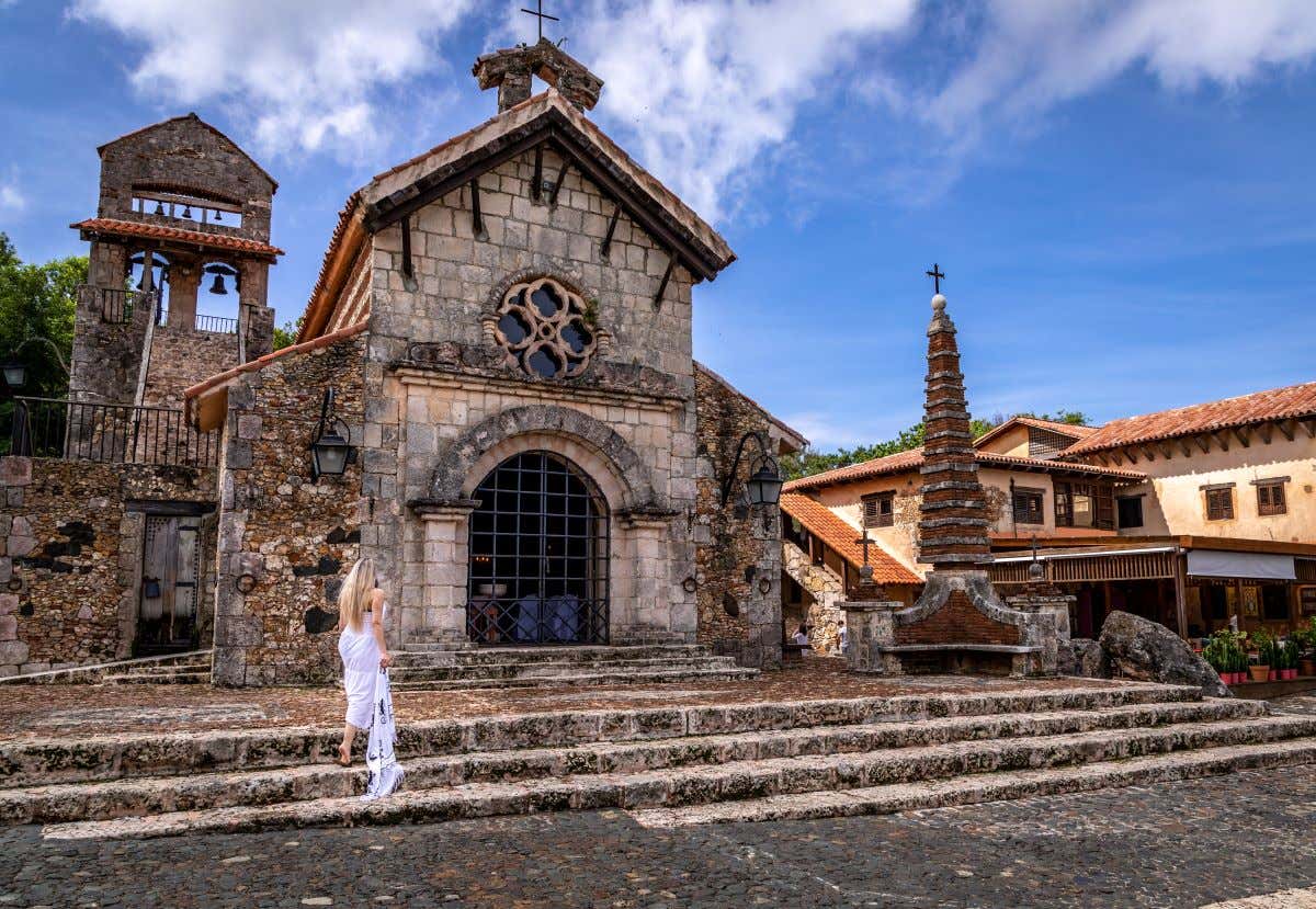 Una mujer caminando hacia la iglesia en Los Altos de Chavón