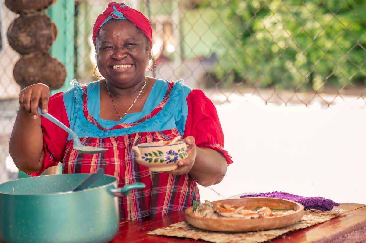 Una mujer afrodescendiente sirve comida en un tazón