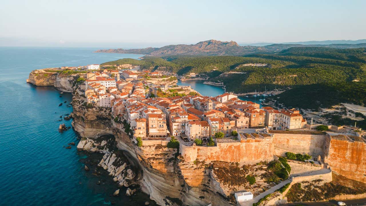 Vue aérienne sur Bonifacio et ses falaises en fin de journée, une magnifique ville où faire une visite lors de vos vacances en Corse