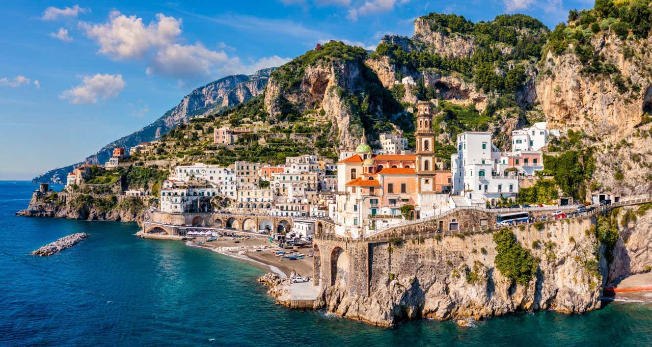 un paesino di estende arroccato sugli scogli che formano la costa a strapiombo sul mare di colore turchese intenso in una mattina soleggiata