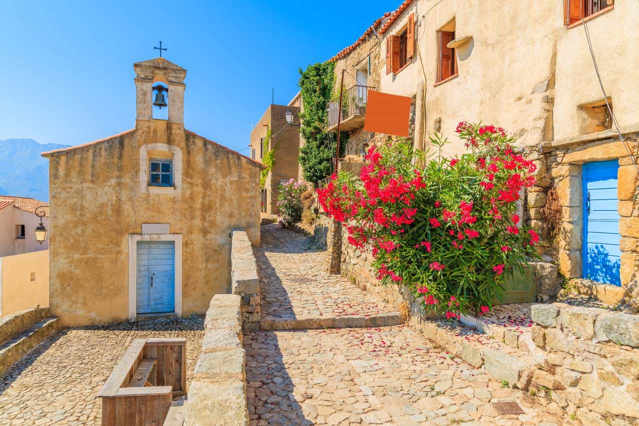 Petite église méditerranéenne, maisons et rues en pierre, fleurs colorées, une visite à faire absolument lors de vos vacances en Corse