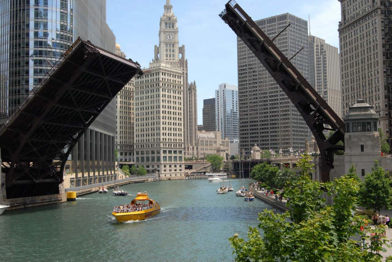 Vue sur les gratte-ciels du centre-ville de Chicago avec la Chicago River et un pont se levant avec un bateau au centre