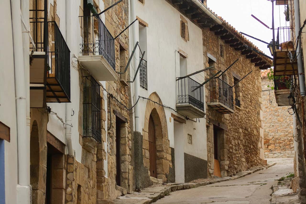 Calle de Vistabella del Maestrazgo con arquitecturas típicas y balcones