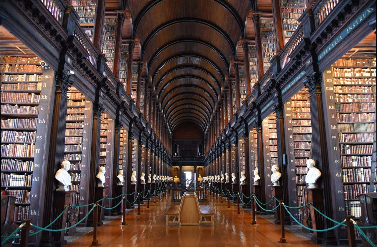 La Long Hall del Trinity College di Dublino, una grande biblioteca in legno con busti in marmo ai lati della sala.