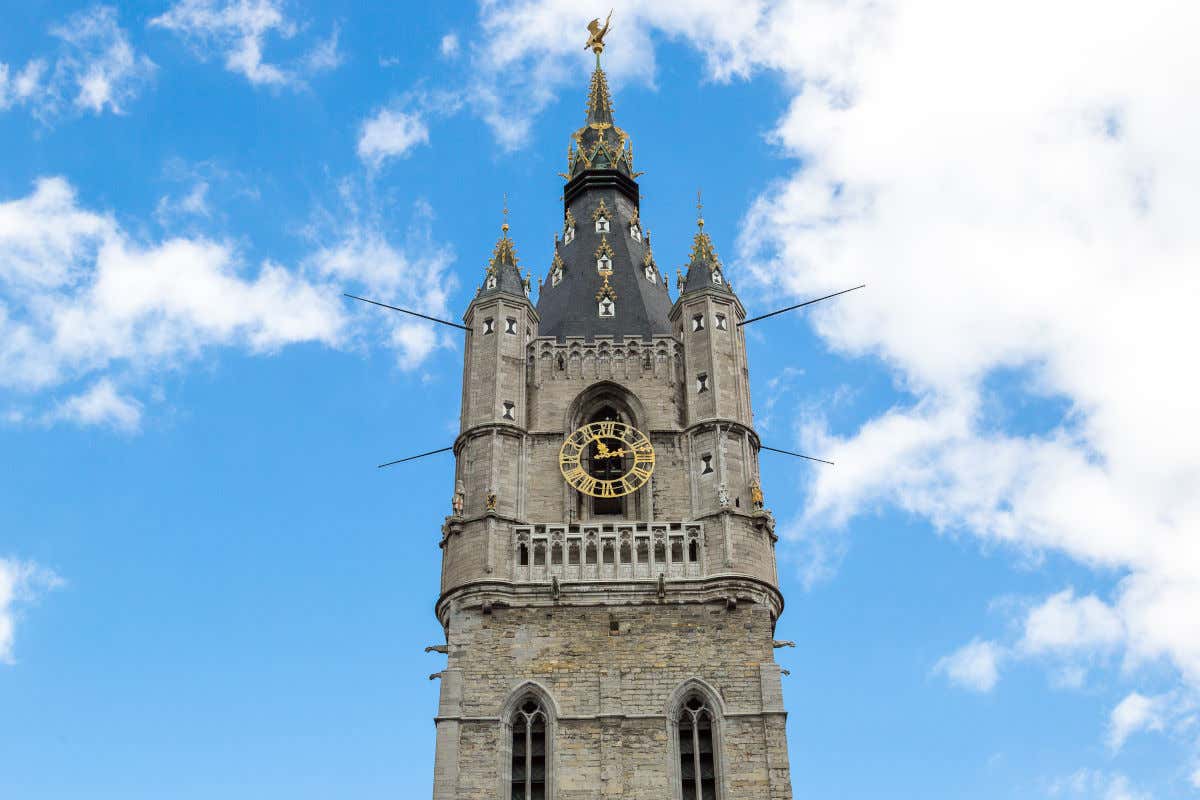 Torre del Campanario de Gante, un torreón de piedra con un reloj dorado y la figura de un dragón en su parte alta