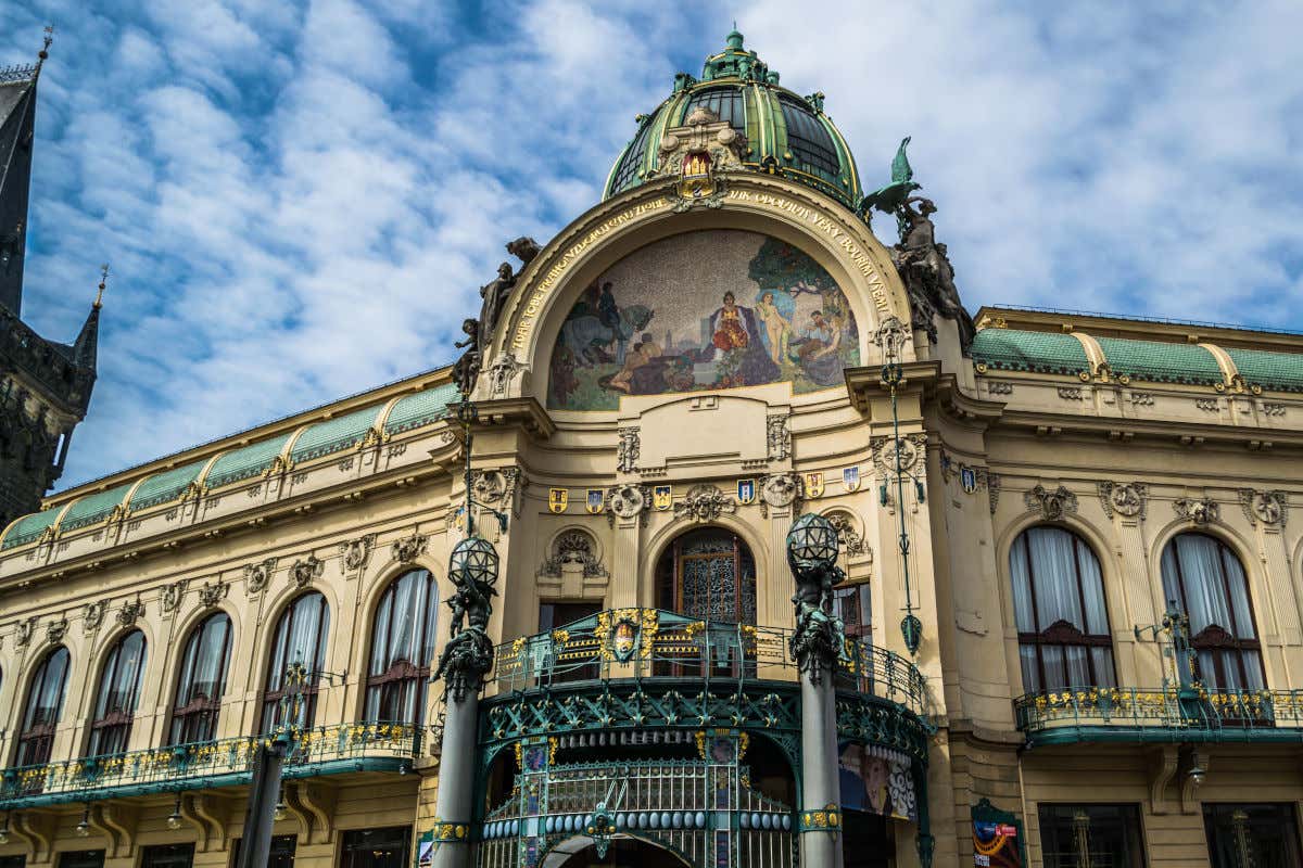 Casa Municipal em Praga, um edifício com decorações pictóricas na fachada e várias sacadas com grades de ferro forjado