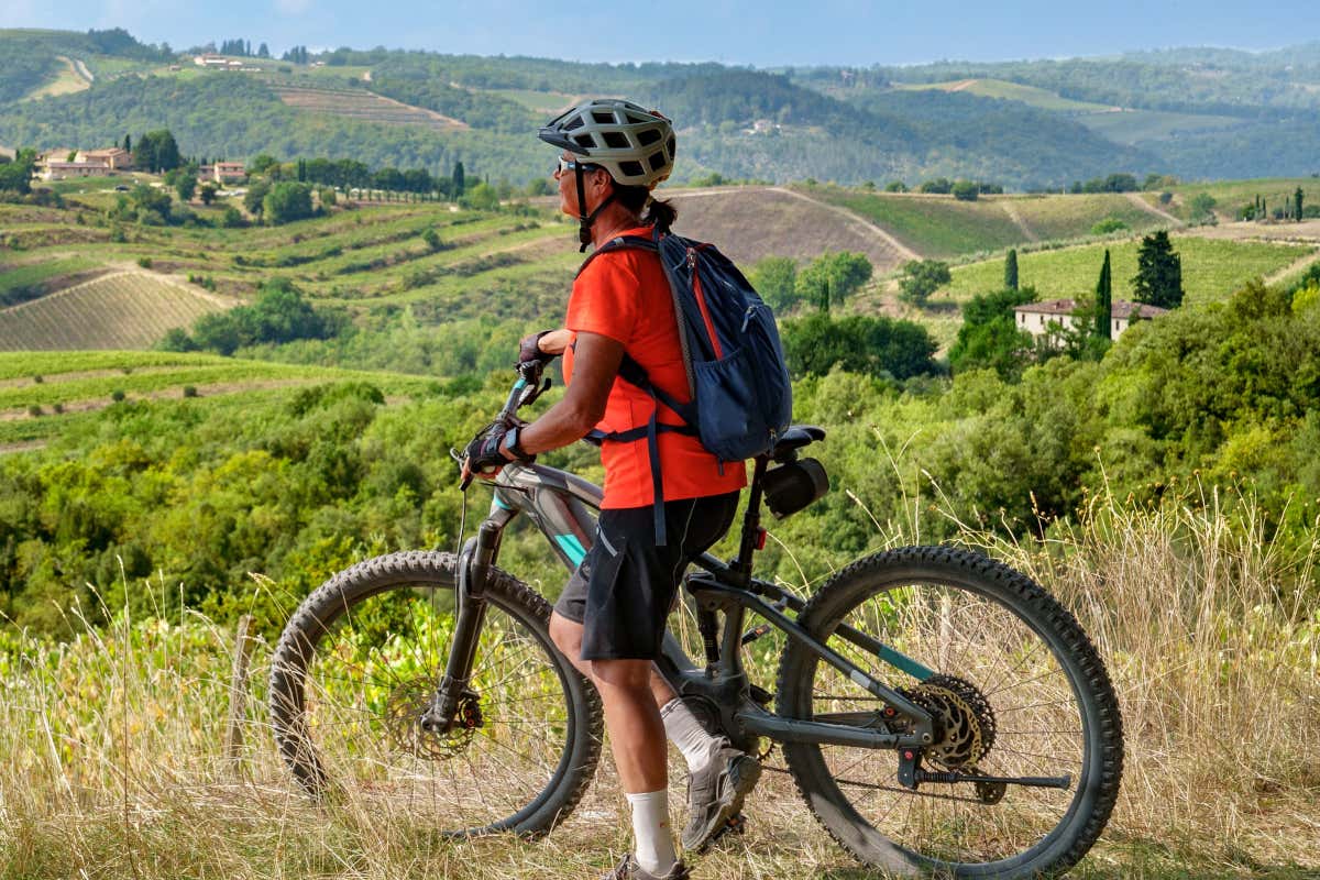 Una mujer recorriendo en bicicleta una vía verde