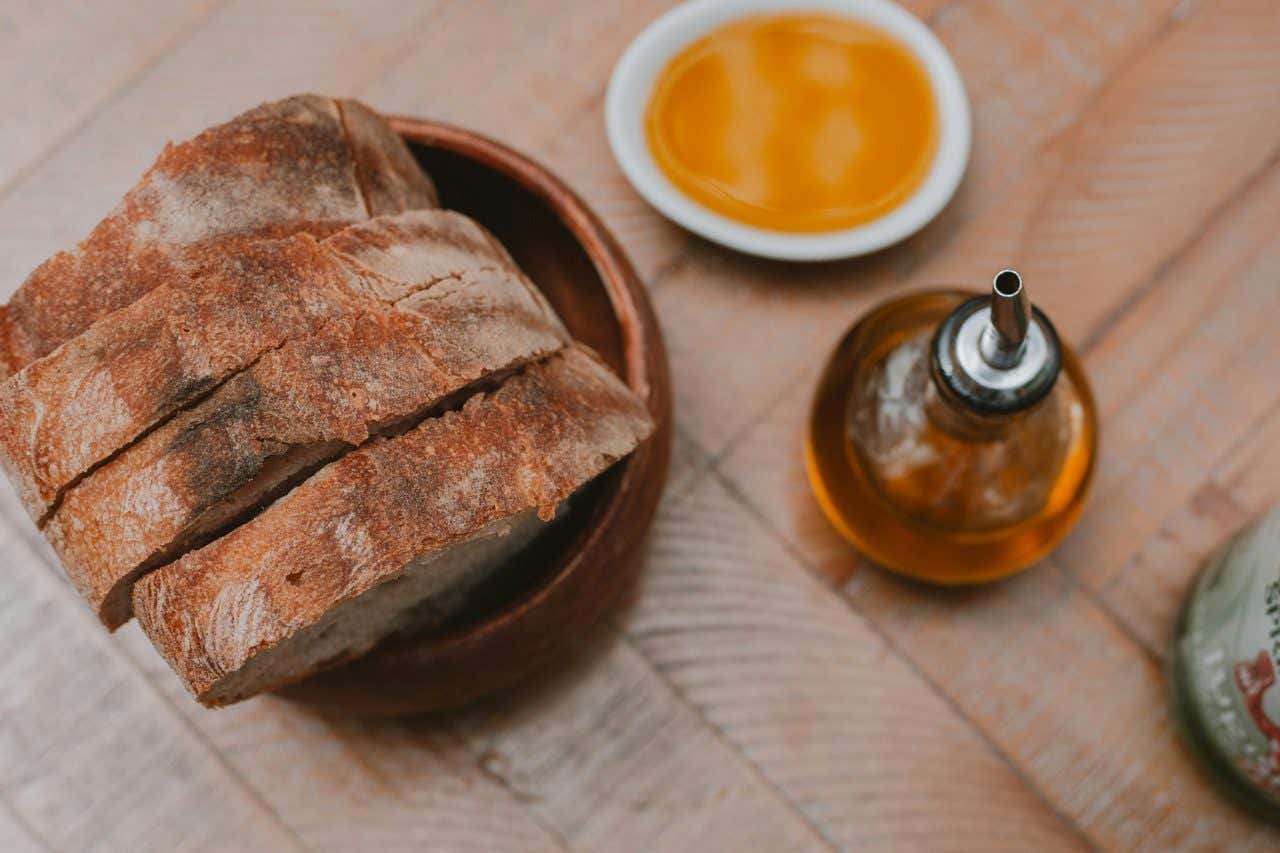 An aerial view of sliced bread next to a jar of olive oil