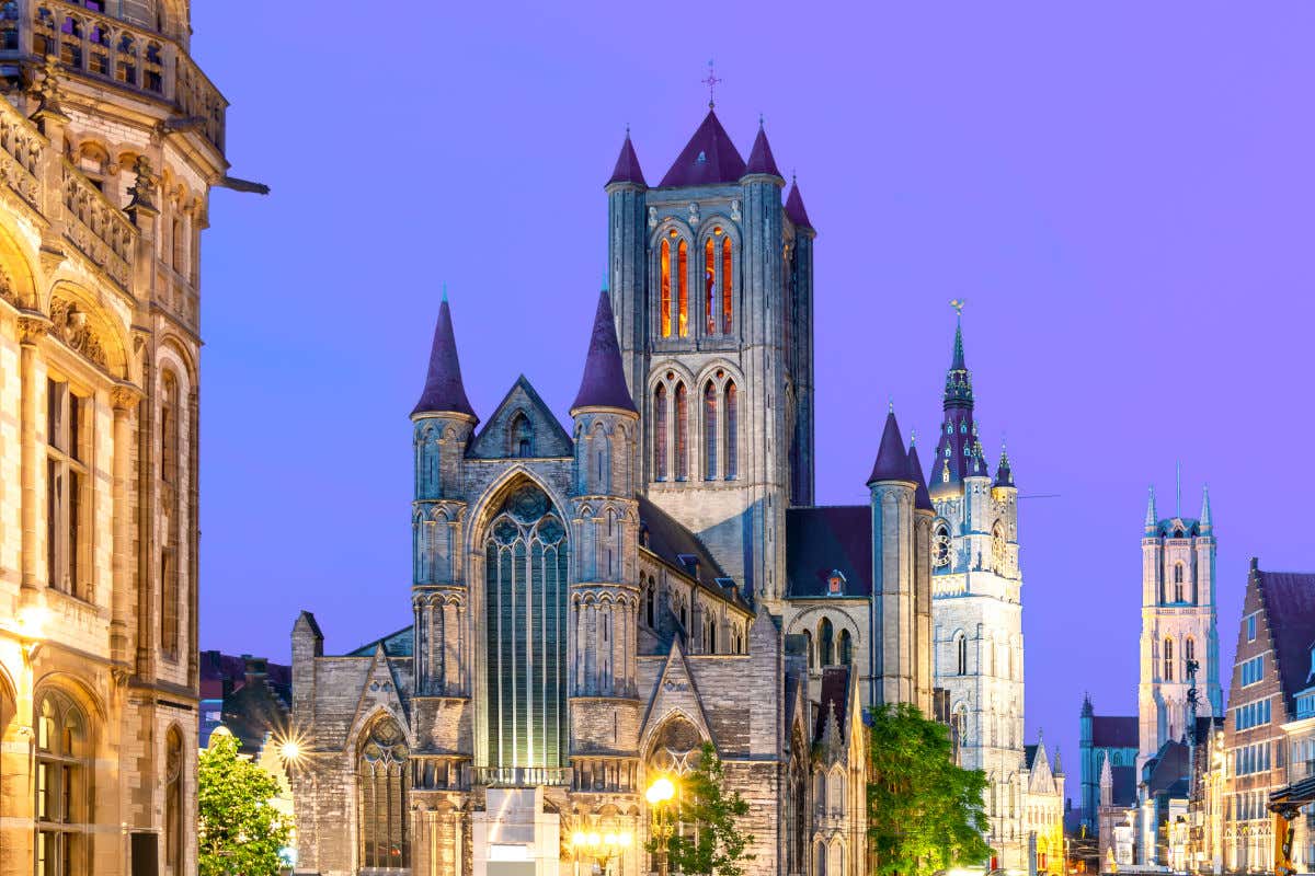 Catedral de San Bavón, un templo de estilo górtico con varias torres iluminadas por la noche