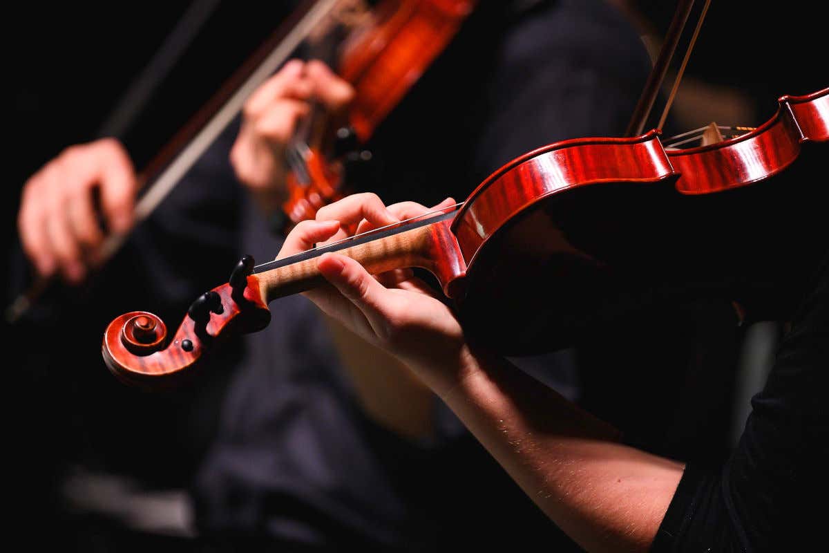 Manos de un músico tocando un violín