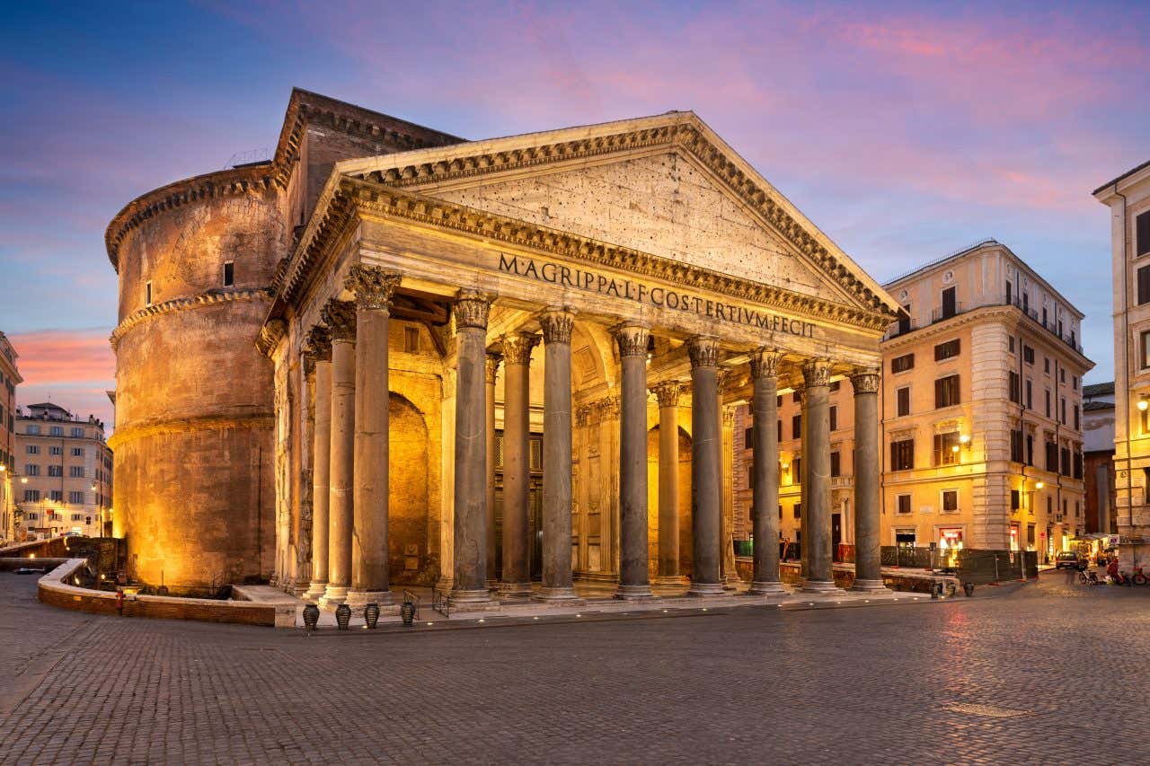 The façade of the Pantheon lit up in the evening.