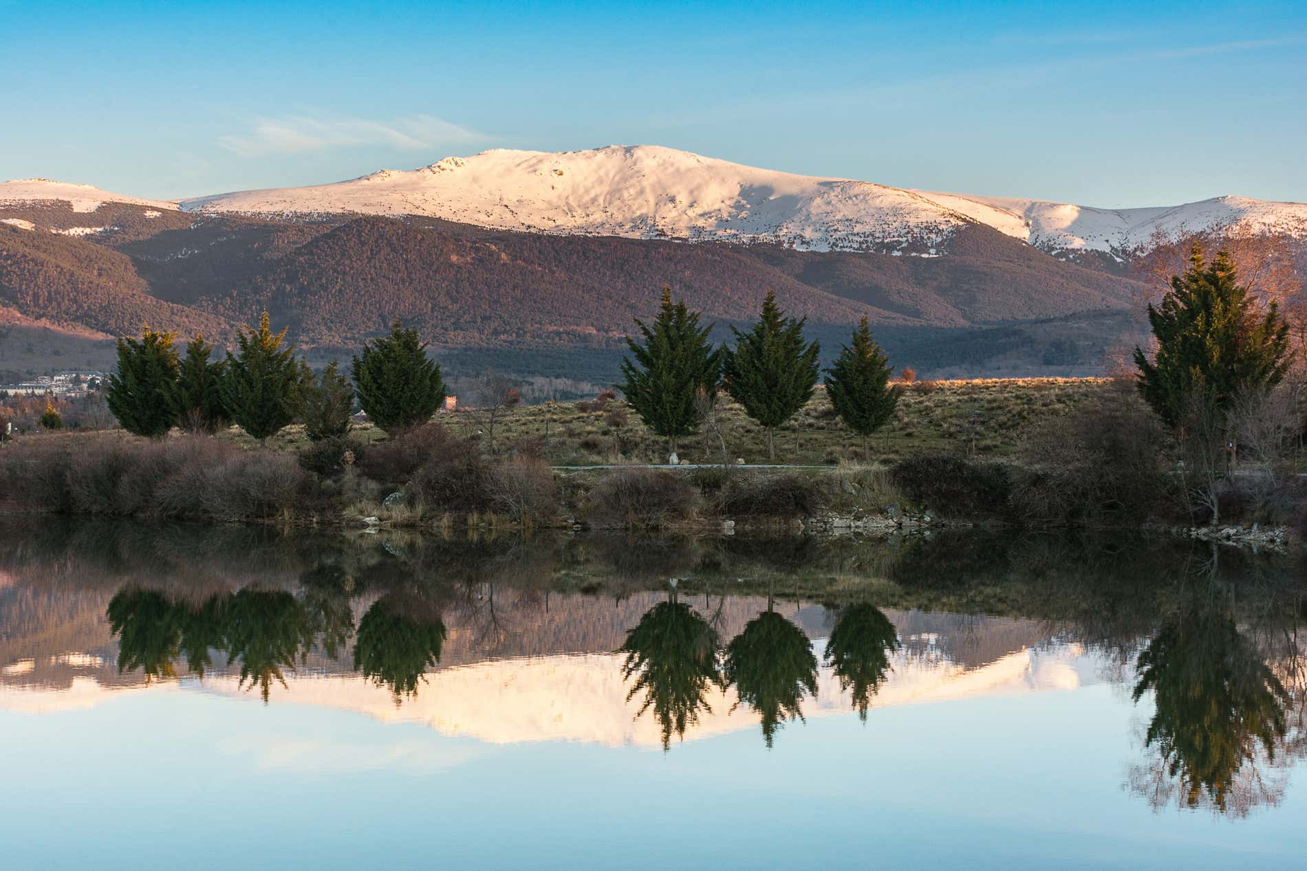 La cima innevata del Peñalara riflessa in un lago.