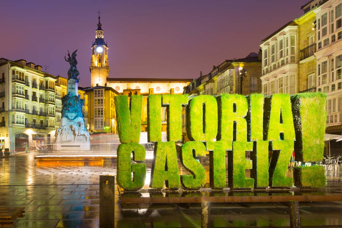 Letras verdes forman la palabra Vitoria-Gasteiz ! en una plaza iluminada por la noche