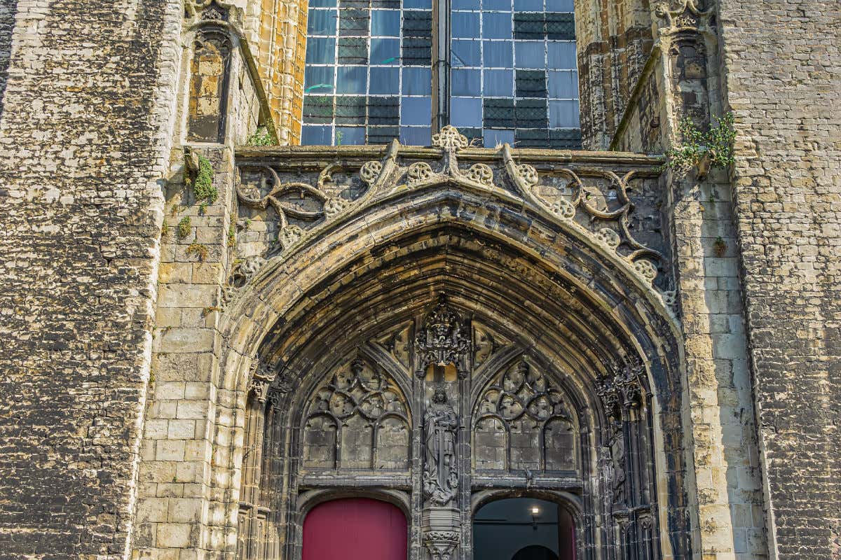 Detalles del pórtico de la iglesia de San Miguel, un templo de piedra con esculturas y decoraciones austeras