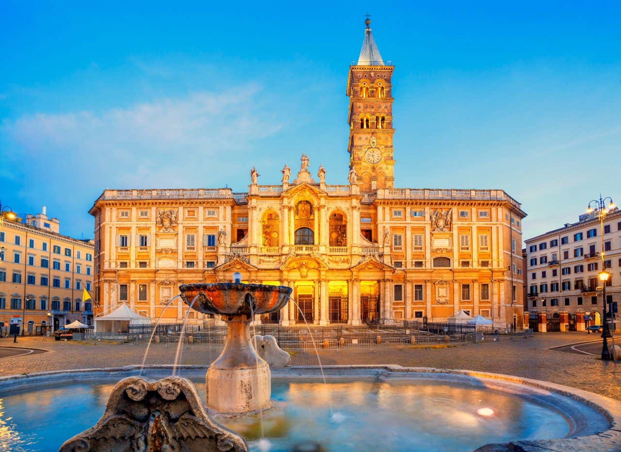 The façade of the Basilica of St Mary Major lit up with golden light.