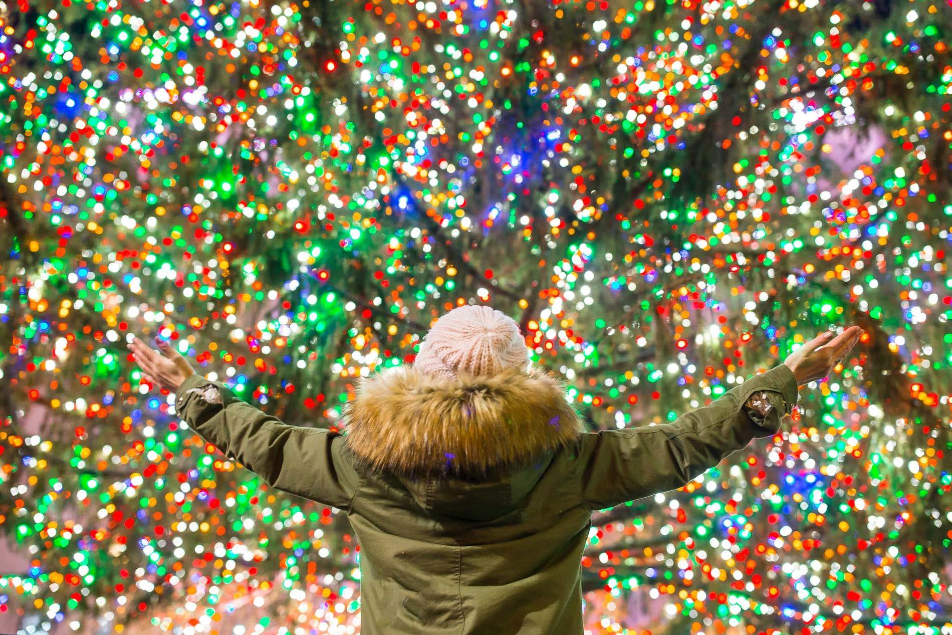 Enfant de dos devant le sapin de Noël illuminé du Rockefeller Center à New York