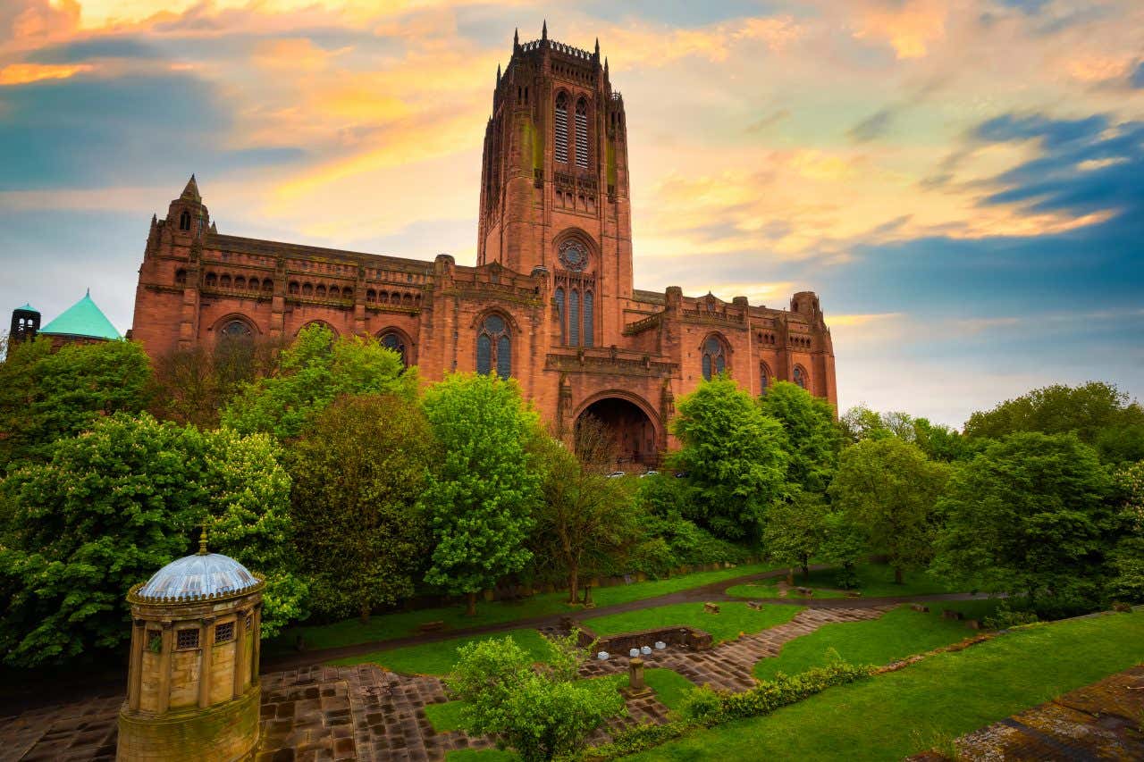 A view of the Liverpool Cathedral during the day with pink and orange clouds in the background.