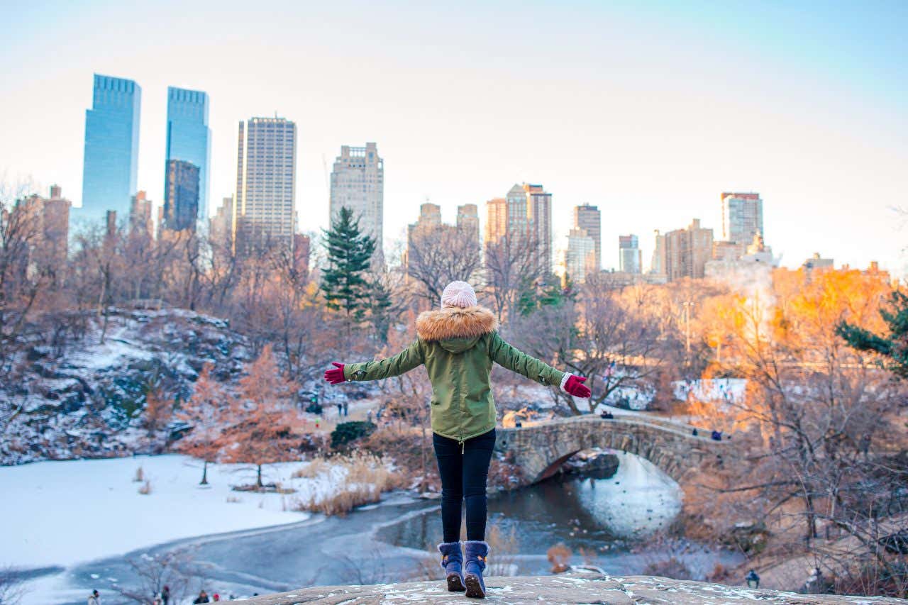 Femme de dos devant le paysage de Central Park en hiver et des gratte-ciels de Manhattan en arrière-plan