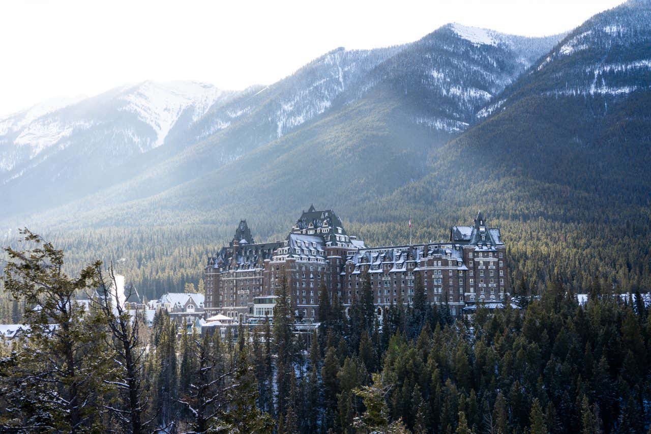 Vue panoramique sur un immense hôtel au cœur d'un paysage de forêts et de montagnes