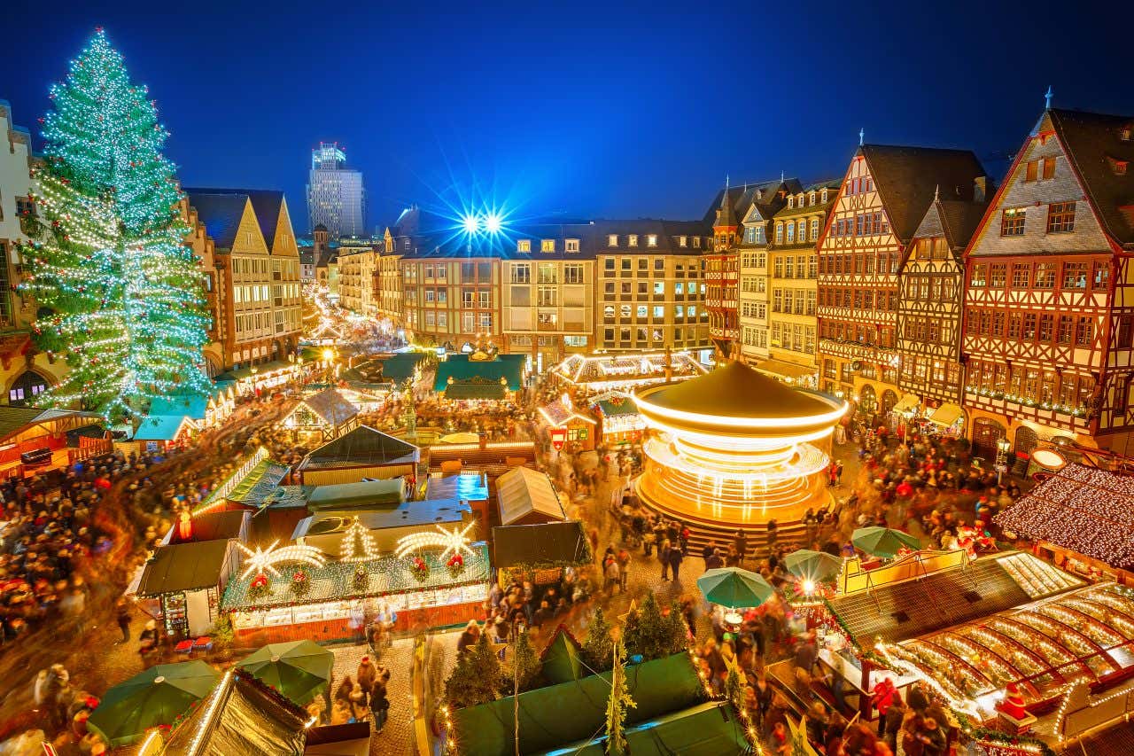 A view of Frankfurt Christmas Market, with stalls covered in golden lights and decorations.