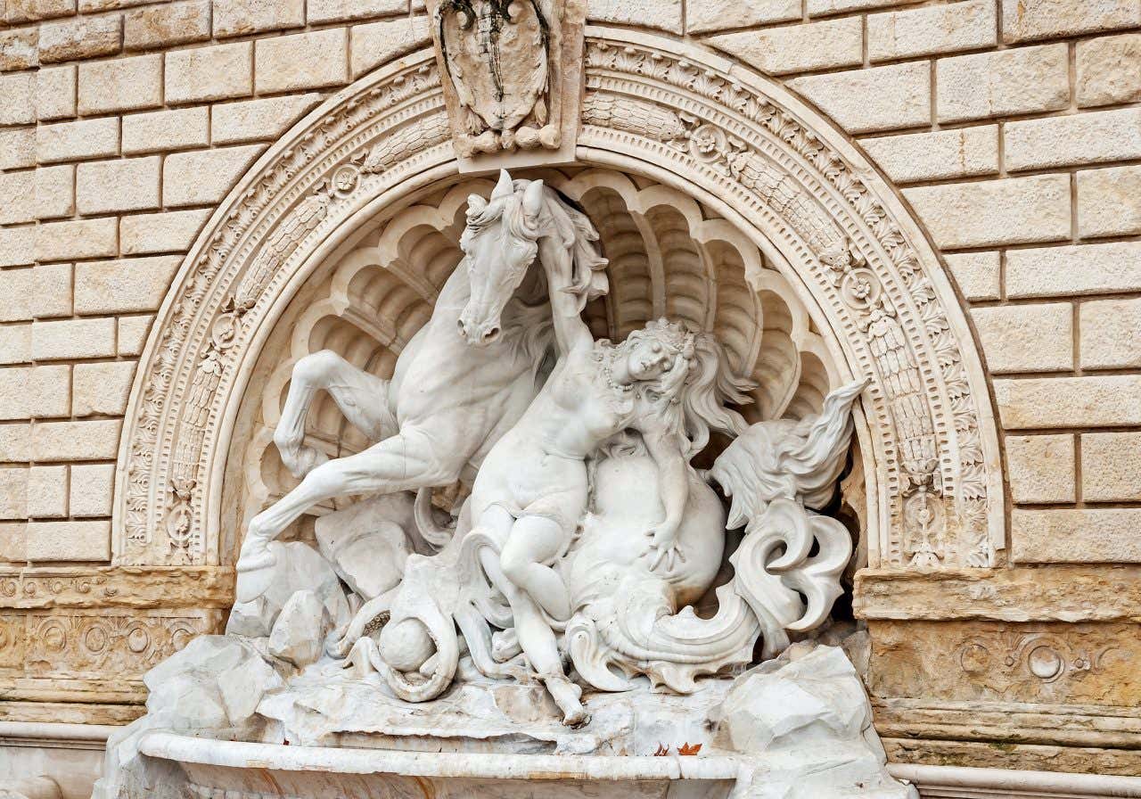 Fontaine avec une statue de femme et d'animaux ainsi que des ornements à l'entrée du parc Montagnola de Bologne 