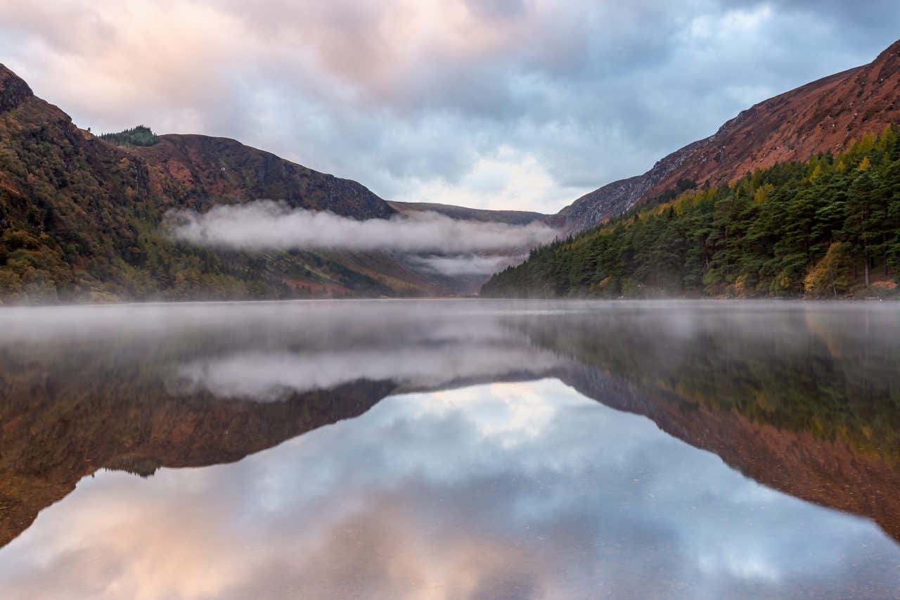 Il lago di Glendalough circondato da montagne e nuvole