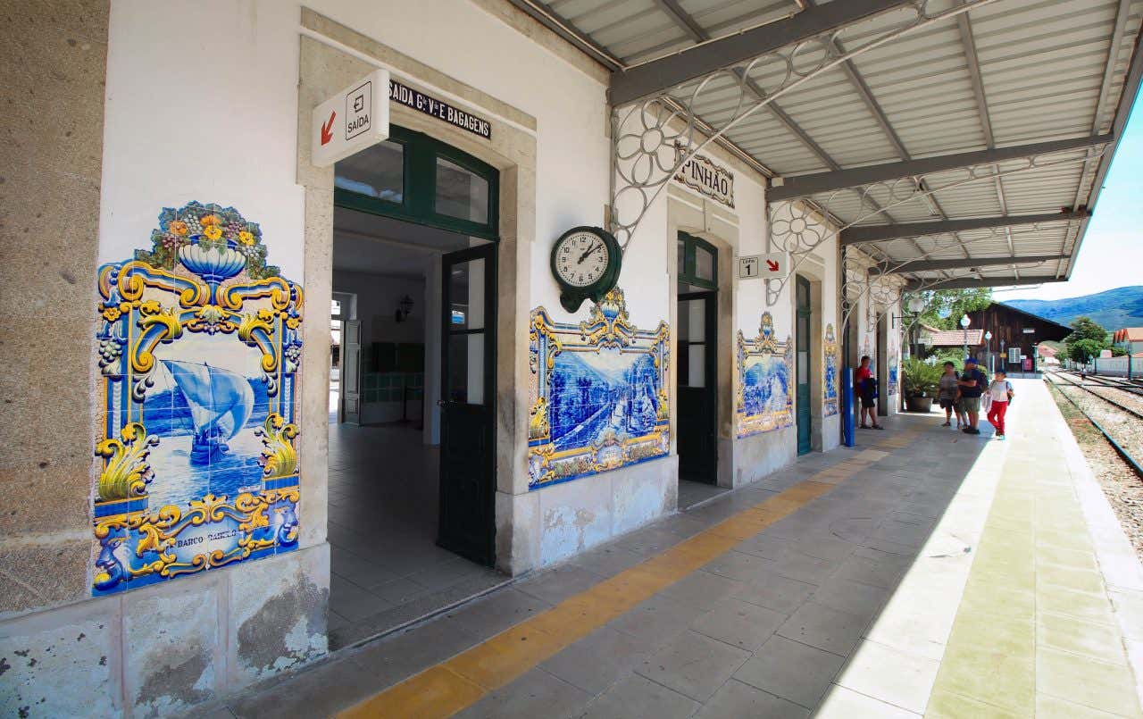 Angled view of the train platform at Pinhao Station in Portugal, with the characteristic blue and yellow azulejo tiles outside