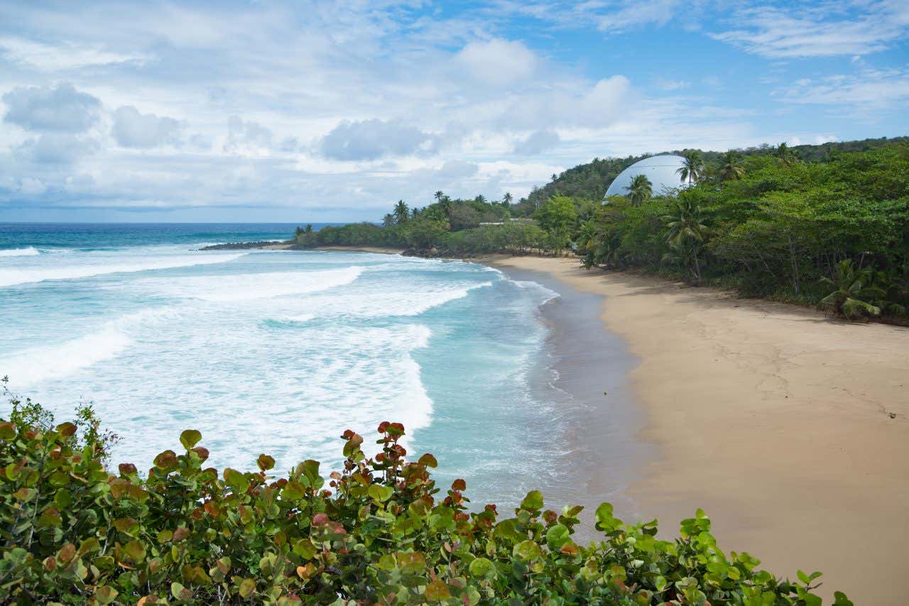 Domes Beach seen from above, with the old nuclear reactor visible in the background.