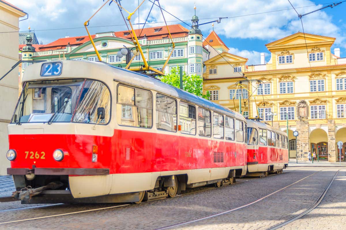 Um bonde antigo em frente a vários edifícios coloridos em Praga