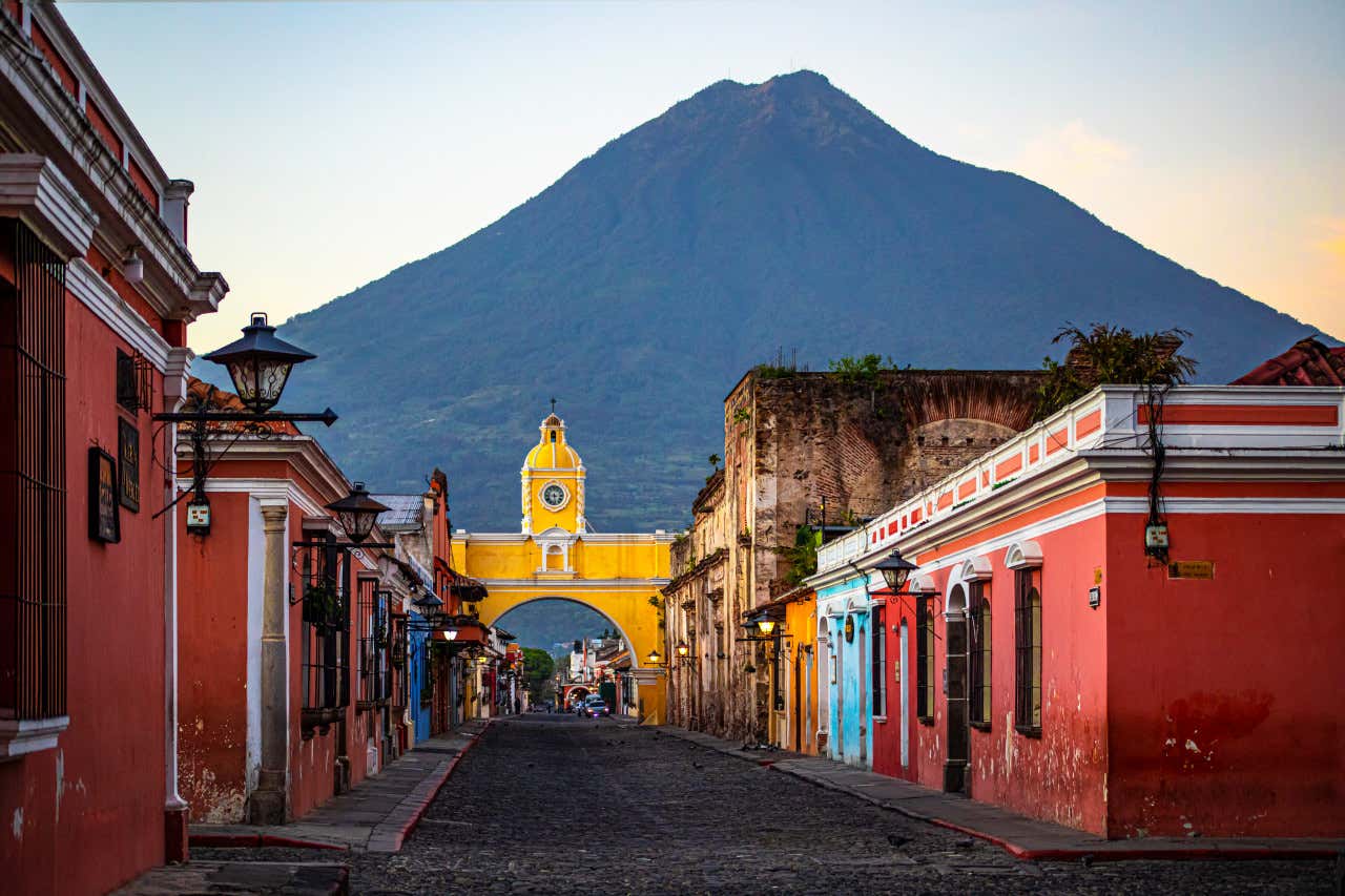 Una calle con edificios coloridos de Antigua Guatemala y al fondo una gran montaña