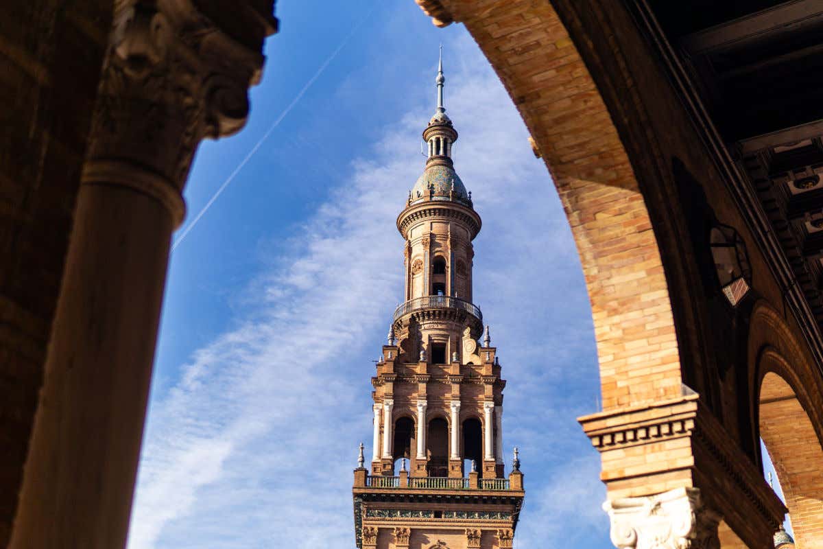 Varios arcos con vistas a una torre de estética mozárabe en la plaza de España de Sevilla