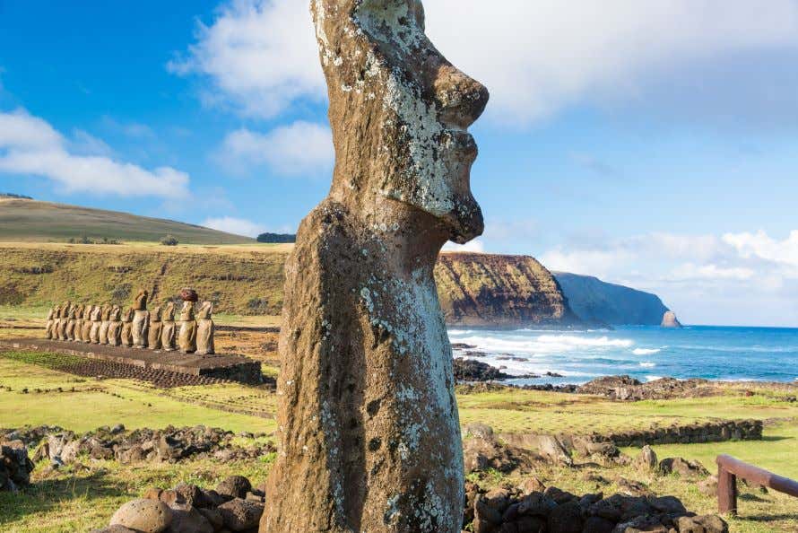 Una estatua moai en primer plano en la Isla de Pascua con el mar de fondo