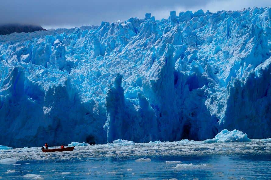 Los imponentes glaciares de Laguna San Rafael donde se aprecia una embarcación frente a ellos