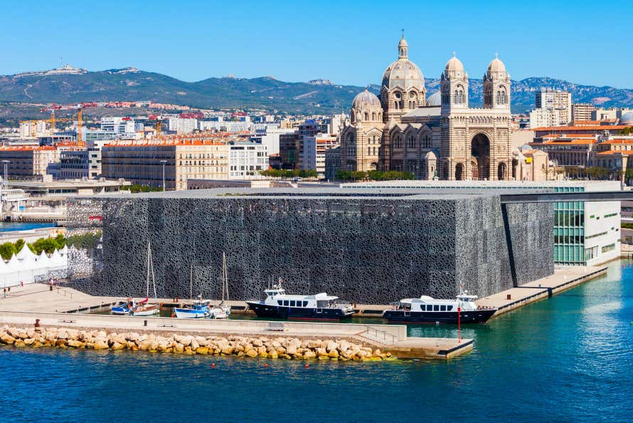 Vista de unos barcos atracados junto al Mucem, el Museo de las Civilizaciones de Europa y del Mediterráneo, con la catedral de Marsella de fondo