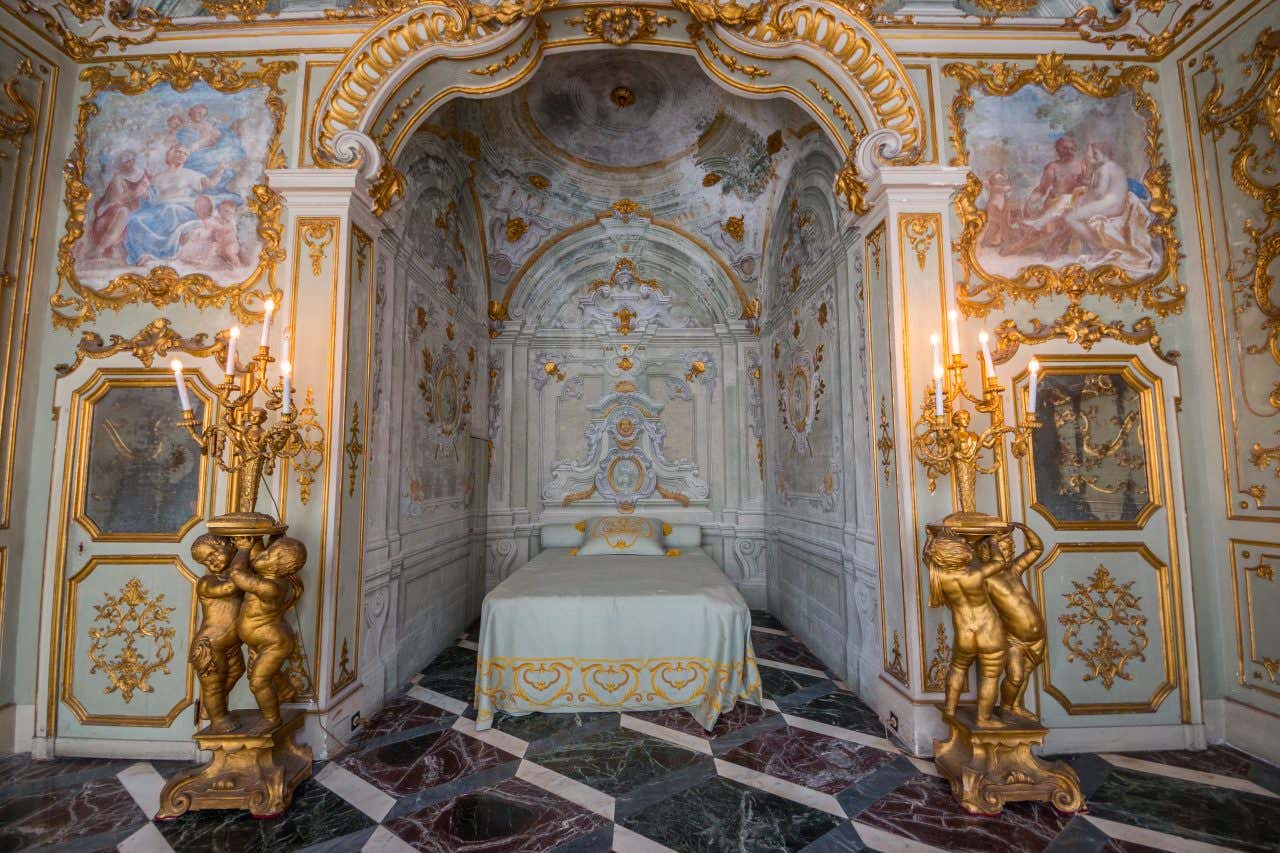 Una camera da letto sontuosa, decorata ovunque con stucchi dorati, affreschi, enormi candelabri in oro sorretti da putti anch'essi in oro, mentre il pavimenti è tappezzato di marmi policromi con venature bianche