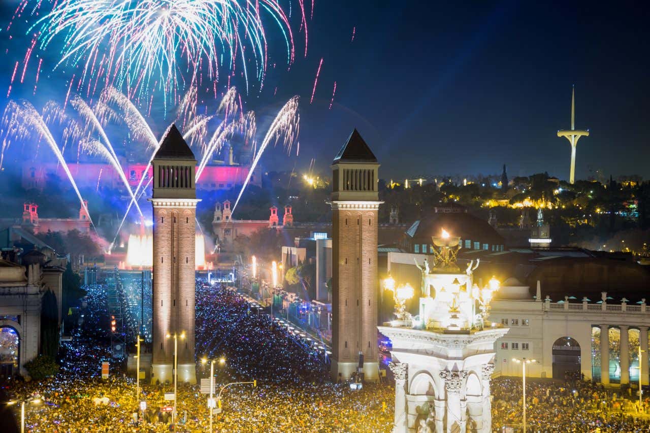 Vue sur la place d'Espagne de Barcelone et son feu d'artifice au-dessus de la foule, une sortie à faire absolument pour le Nouvel An