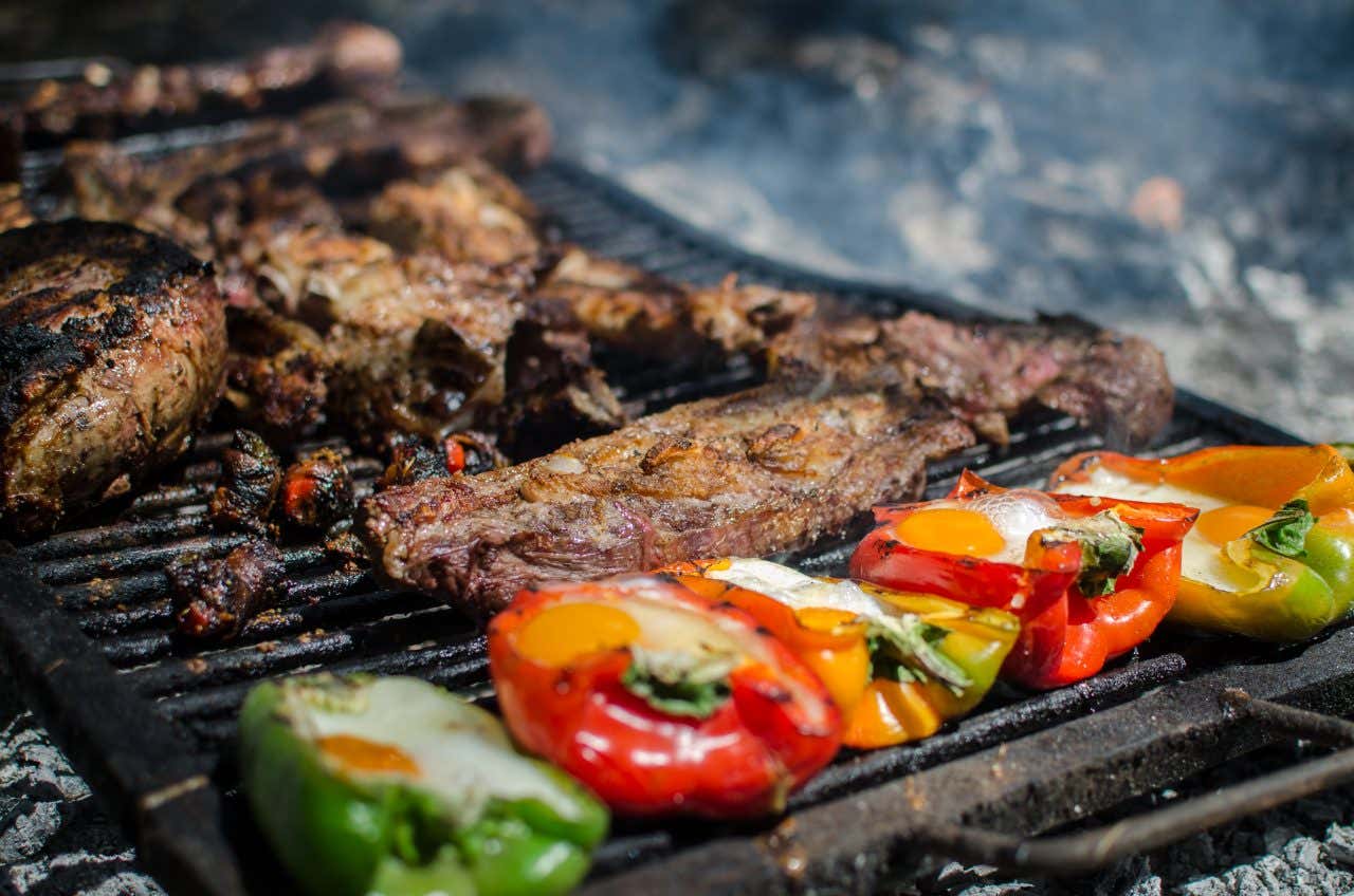 Viande et poivrons cuisant sur une parrilla (grill)