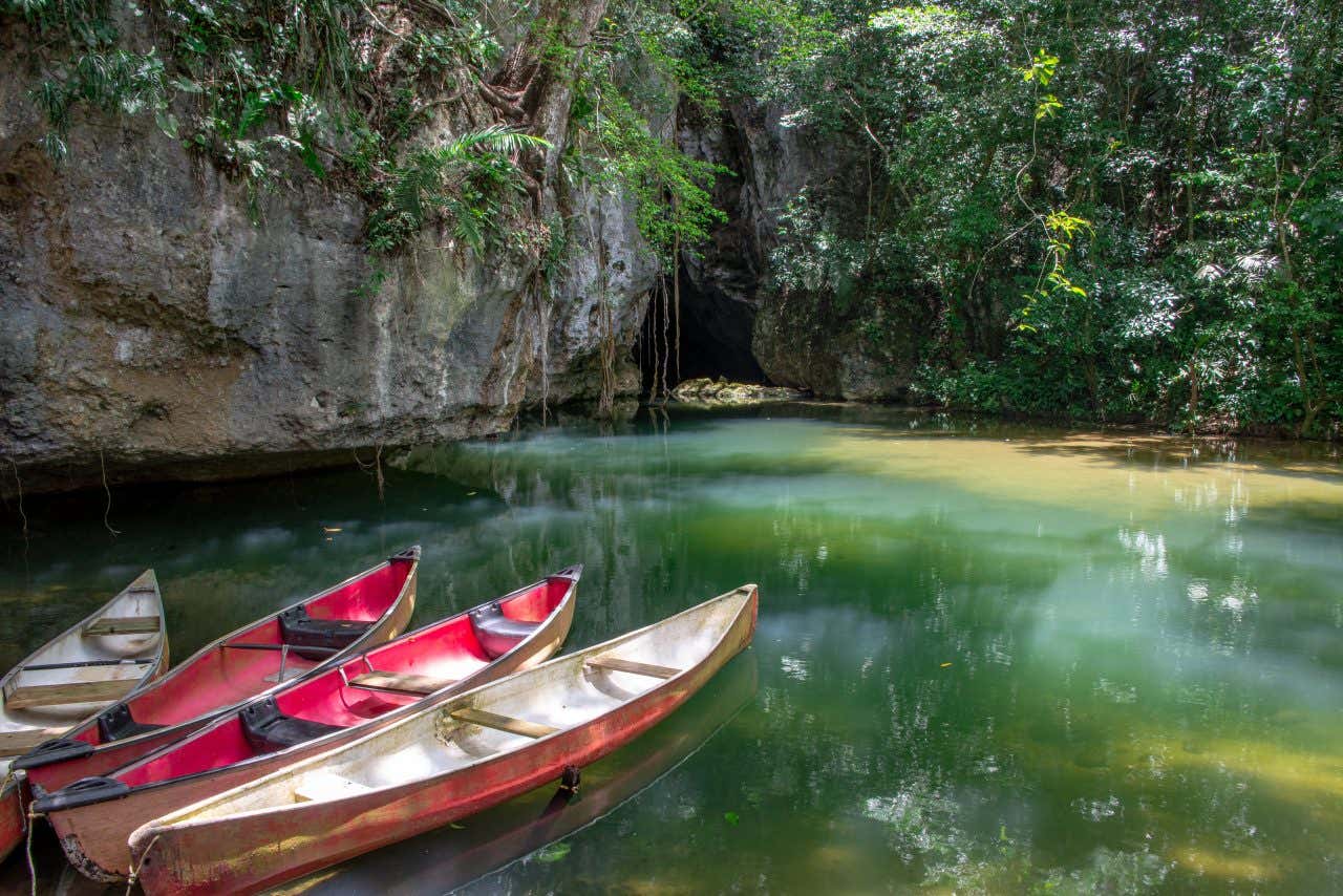  Barton Creek Cave as seen from across the water with 4 wooden boats in the foreground on the left.